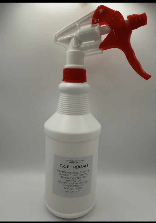 White spray bottle with red trigger labeled as all-natural fabric spray made with distilled water, witch hazel, baking soda, and tea tree oil for fabric odor elimination.