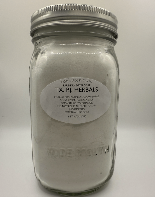 Jar of all-natural laundry detergent made with baking soda and essential oils in clear glass container