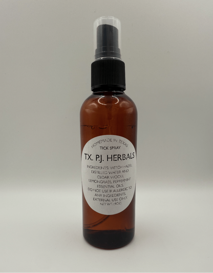All-natural tick spray in amber 4 oz bottle with black spray top, made with witch hazel, essential oils, and cedar wood for safe tick repellent.