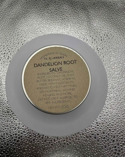 All-Natural Dandelion Root Salve in a jar with fresh dandelions and green leaves for natural skin care